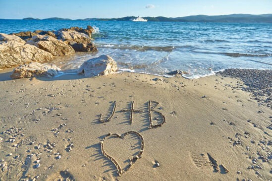 J plus B with heart written on sandy beach in Croatia.
